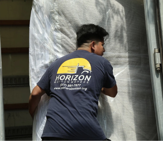 Horizon Boston Movers crew member wrapping furniture in plastic film