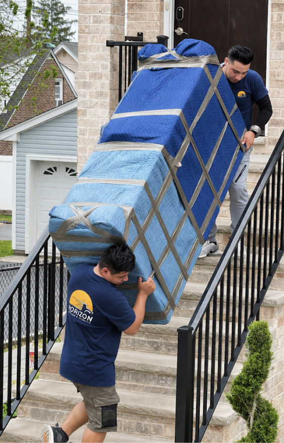 Horizon Boston Movers crew carrying a wrapped item up exterior stairs