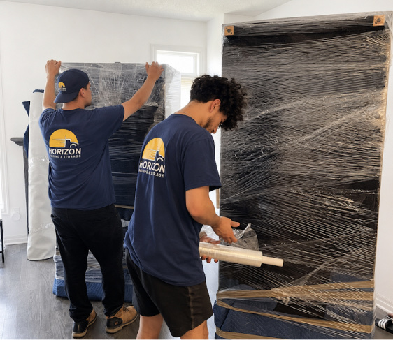 Horizon Boston Movers crew wrapping a large item indoors